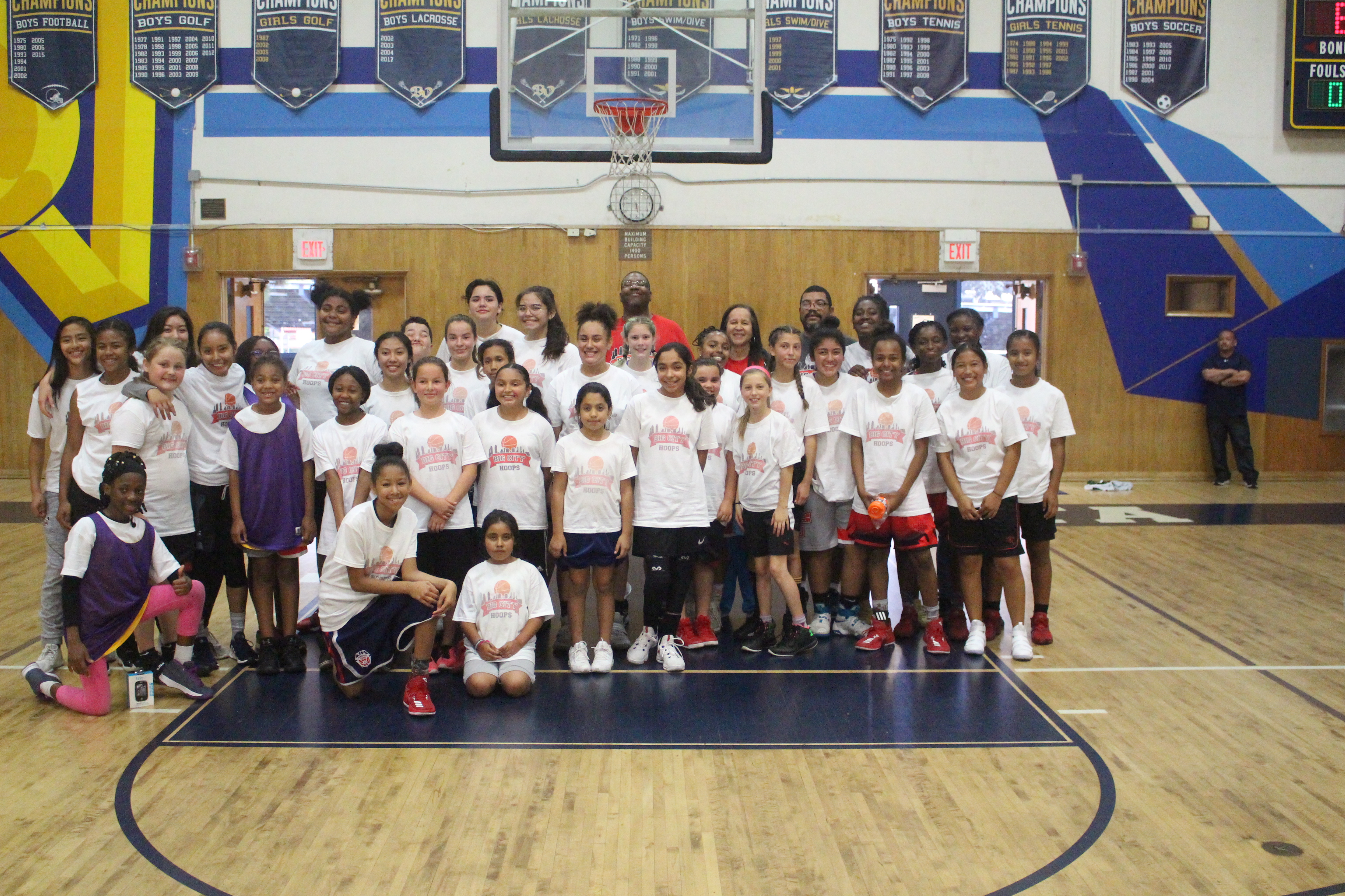 A group of people standing on top of a basketball court.