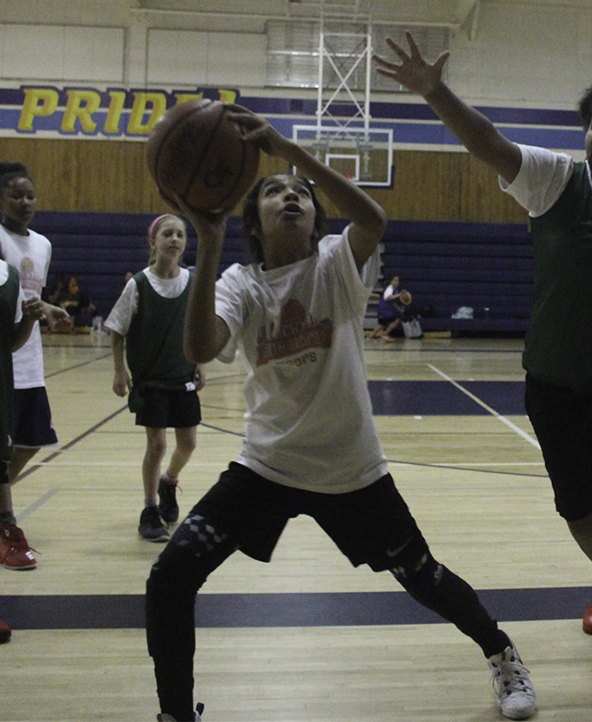 A group of people playing basketball on a court.