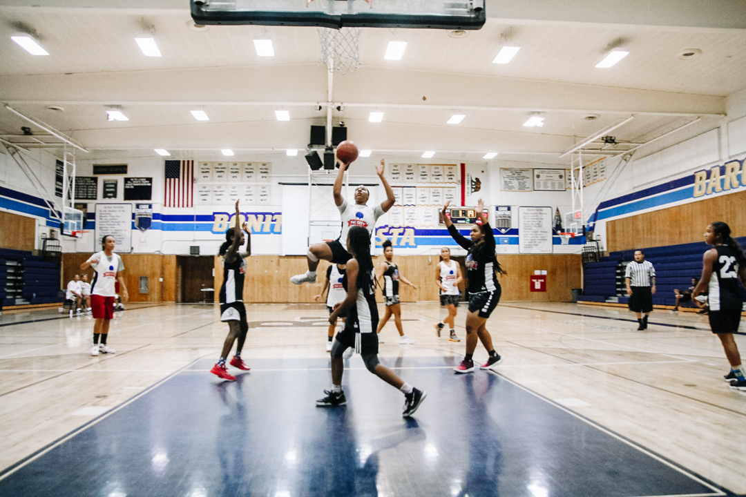 A group of people playing basketball on a court.