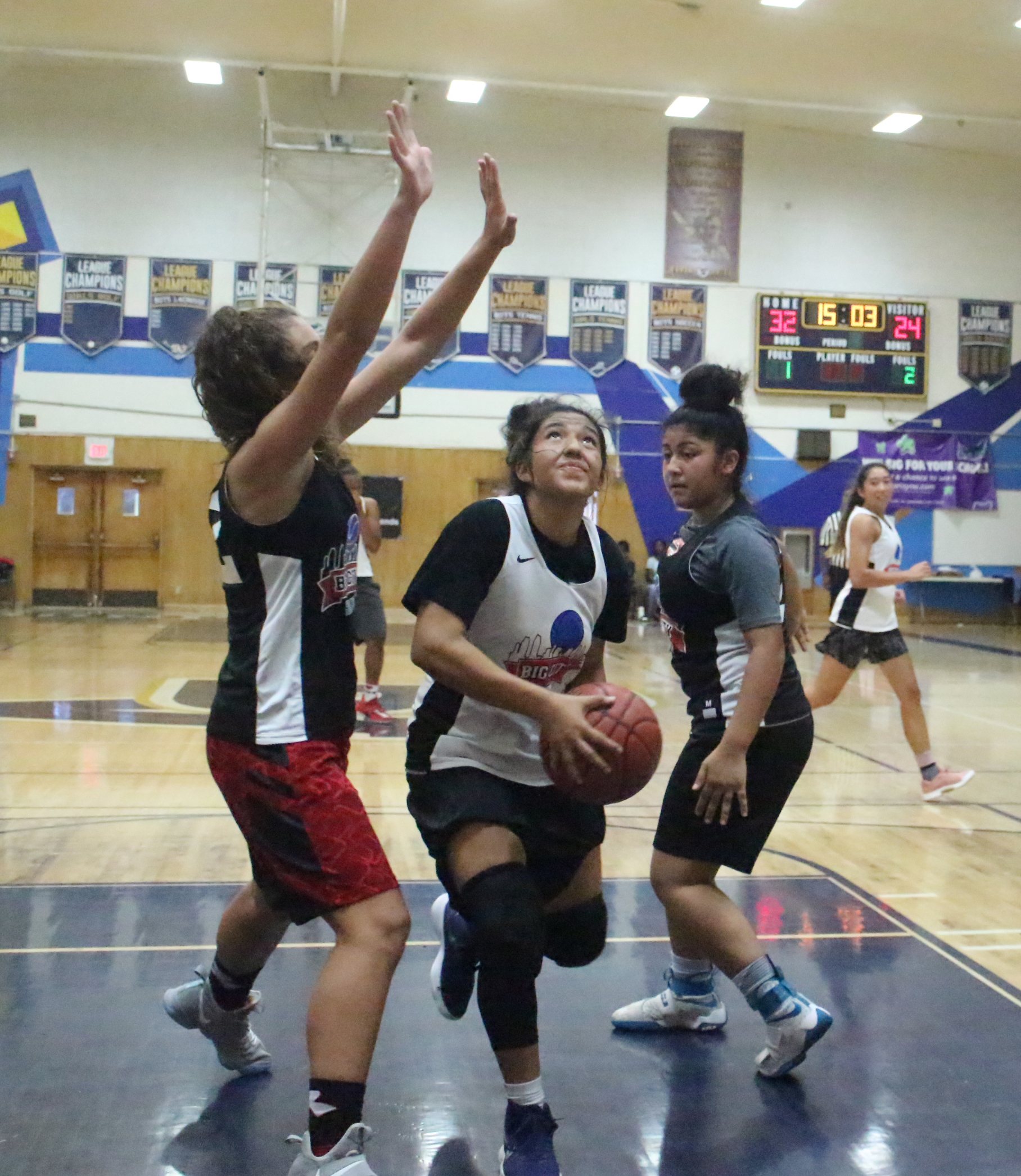 A group of young people playing basketball on a court.